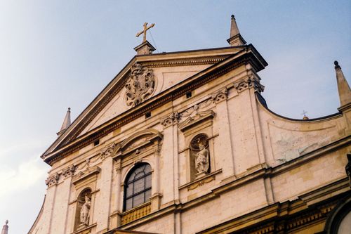 Free A detailed view of a historic Baroque church facade with ornate statues in Kraków, Poland. Stock Photo
