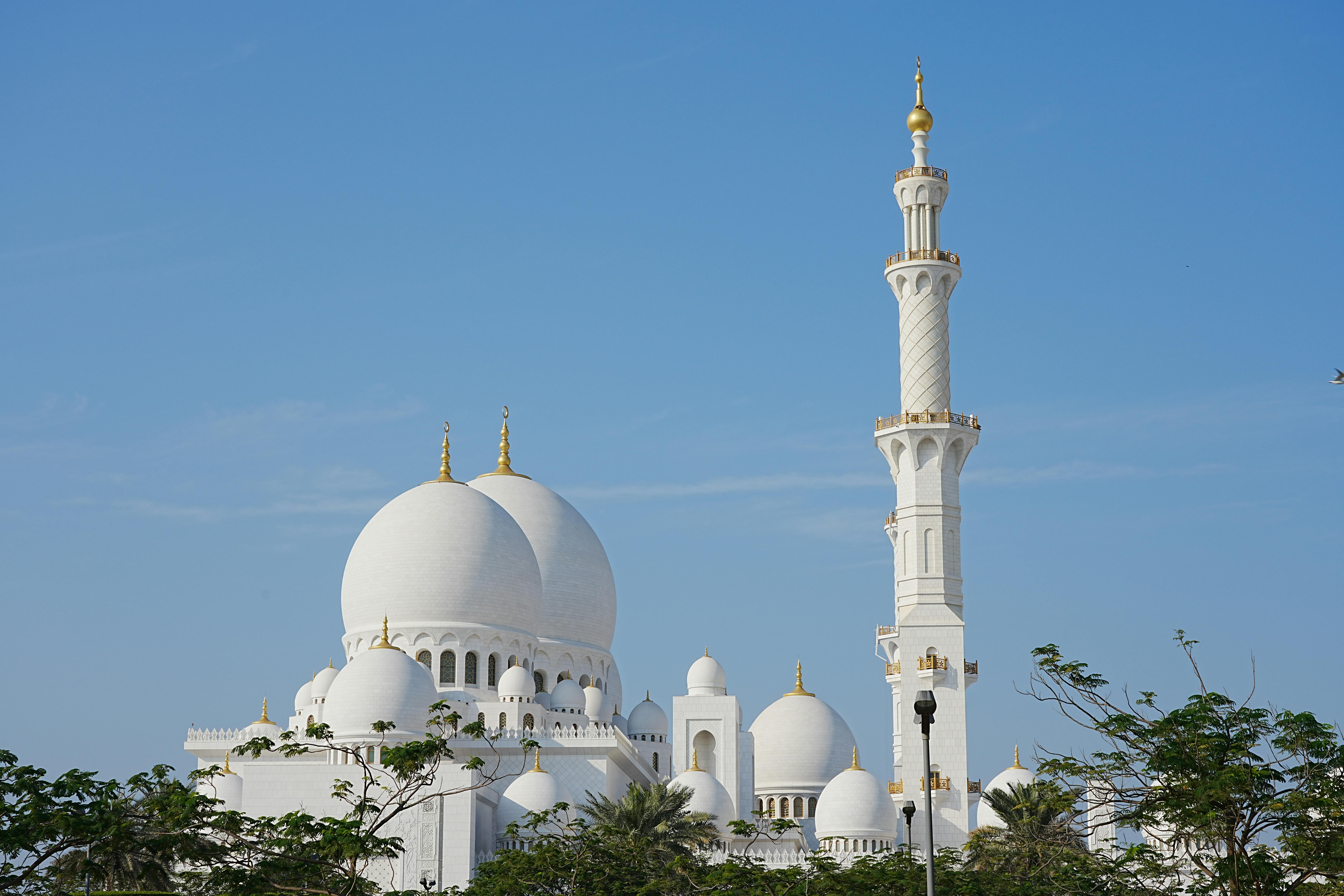 Majestic view of Sheikh Zayed Grand Mosque under bright blue sky in Abu Dhabi, UAE.