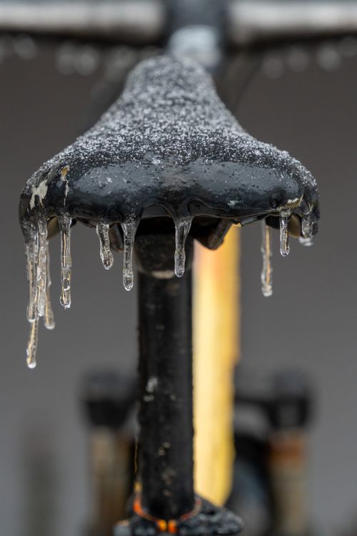 Free Close-up of a bicycle seat covered in frost and icicles during winter. Stock Photo