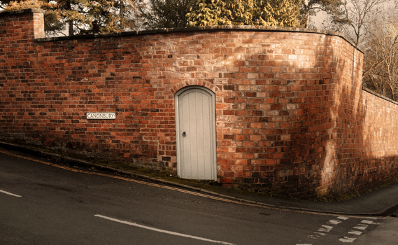 A classic brick wall with an old door and street sign in Shrewsbury, UK.