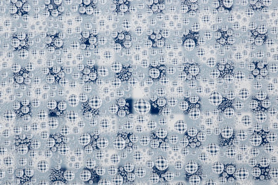 Close-up of abstract bubbles forming patterns on a blue checkered background.