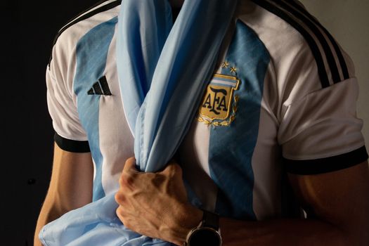 Close-up of a man holding an Argentina soccer jersey symbolizing sports enthusiasm.