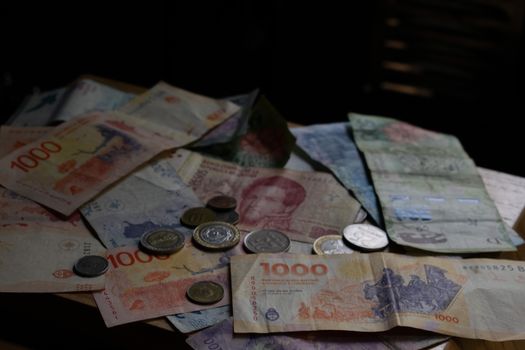 A collection of various international banknotes and coins scattered on a table.
