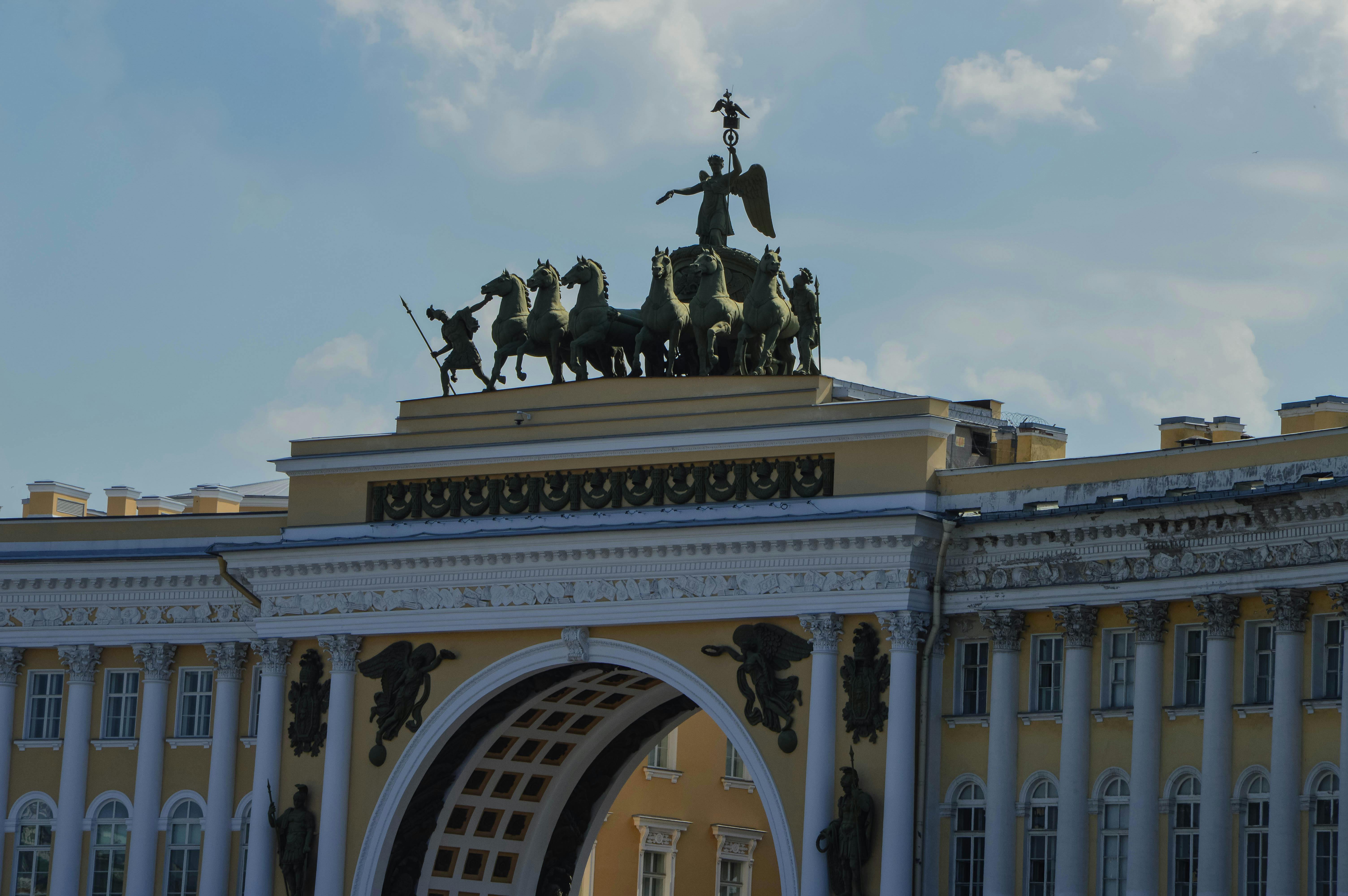 Close-up of the ornate Triumphal Arch with a majestic chariot sculpture under a clear sky