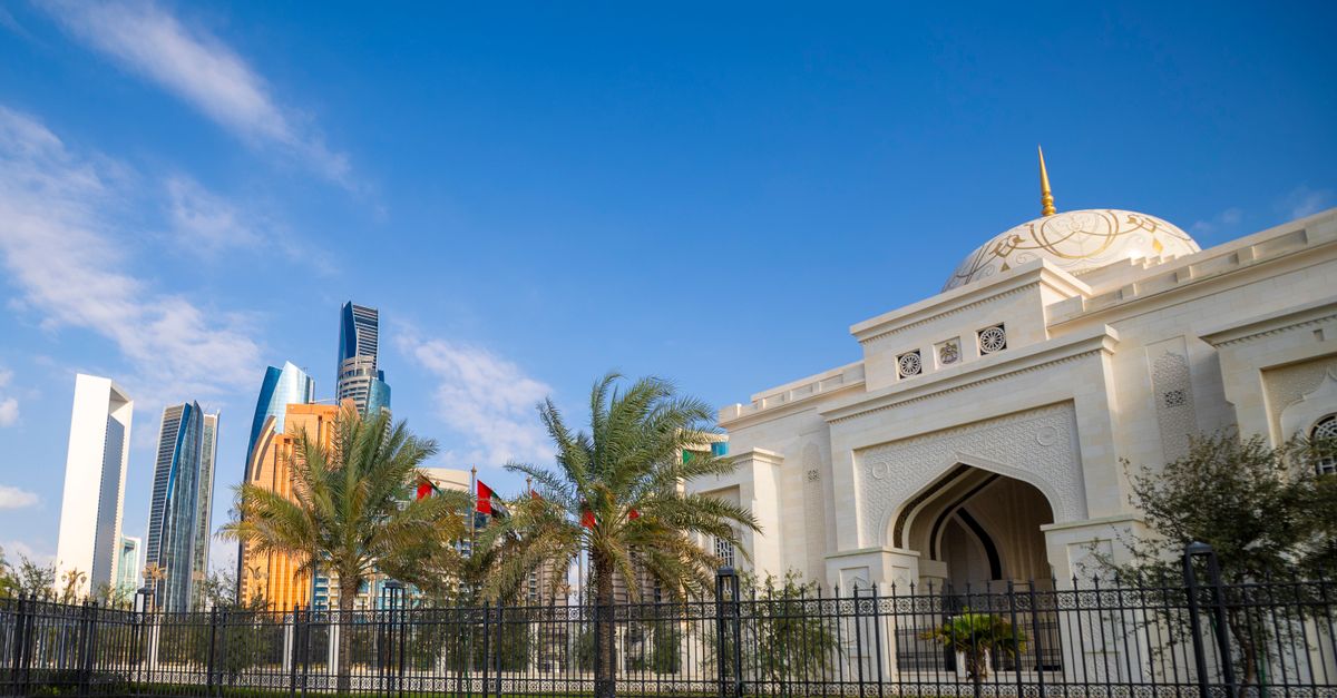 A breathtaking view of Abu Dhabi's skyline with a stunning mosque in the foreground under a clear bl