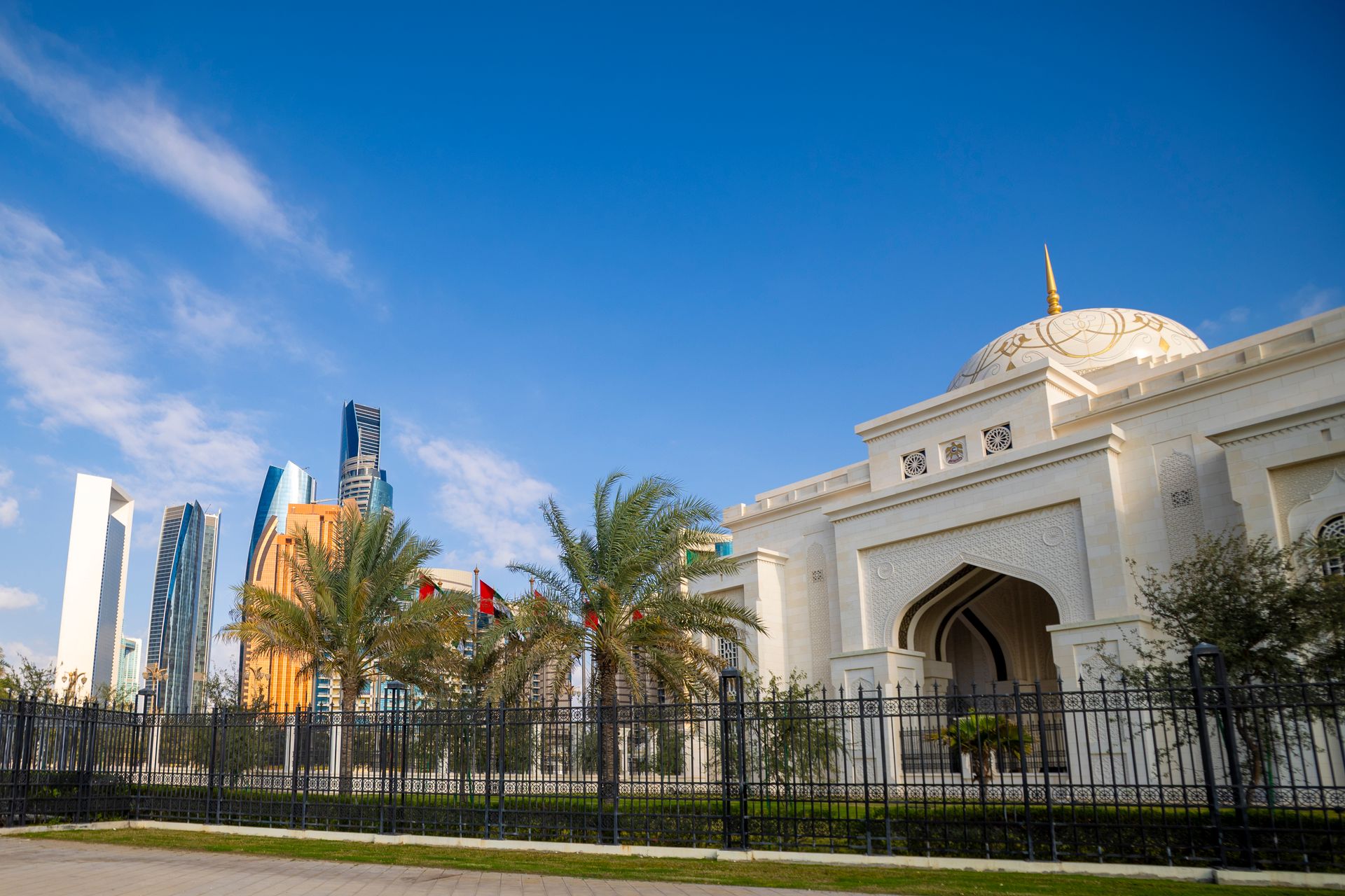A breathtaking view of Abu Dhabi's skyline with a stunning mosque in the foreground under a clear bl