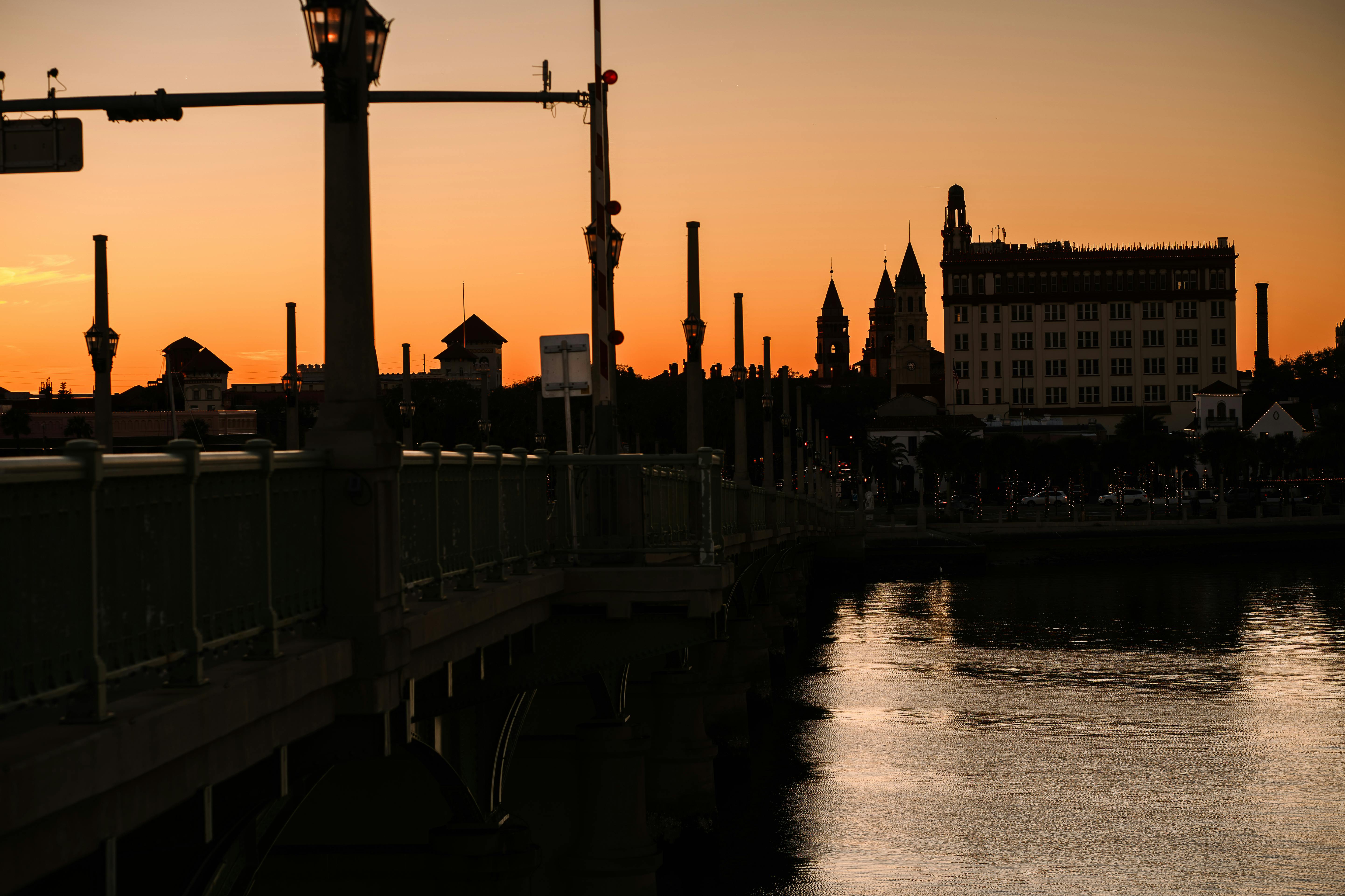 Silhouette of St. Augustine skyline at sunset with warm hues and reflections.