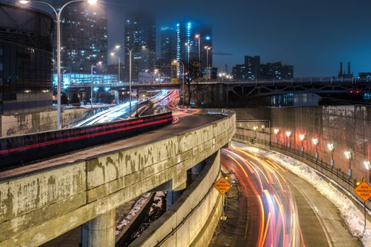 Vibrant night scene of Chicago city with light trails from moving cars on an urban highway.