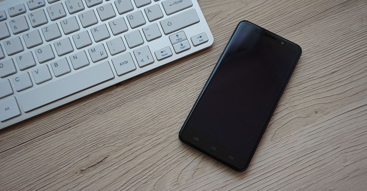 Ruhiger arbeiten in der lauten Stadt: Die eigene Arbeitsecke für Berlins Kreative und Freelancer 2 Tastatur und Smartphone auf einem Holztisch, nah aufgenommen als moderne Arbeitsutensilien