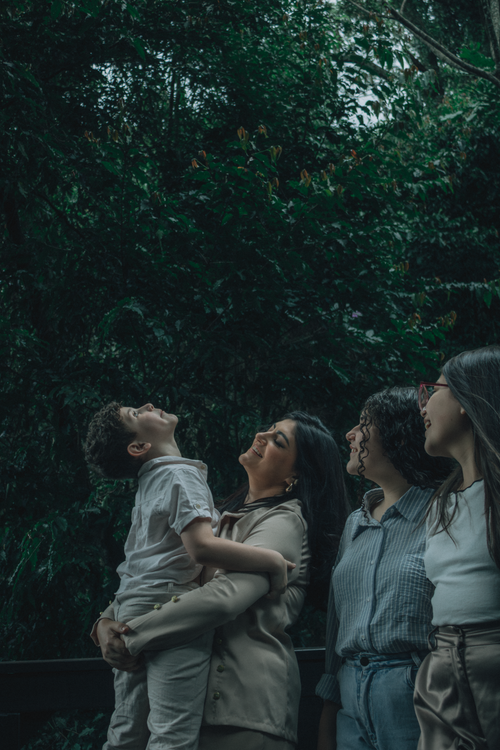 Free Group of people embracing nature in a lush, green forest environment, portraying harmony and joy. Stock Photo