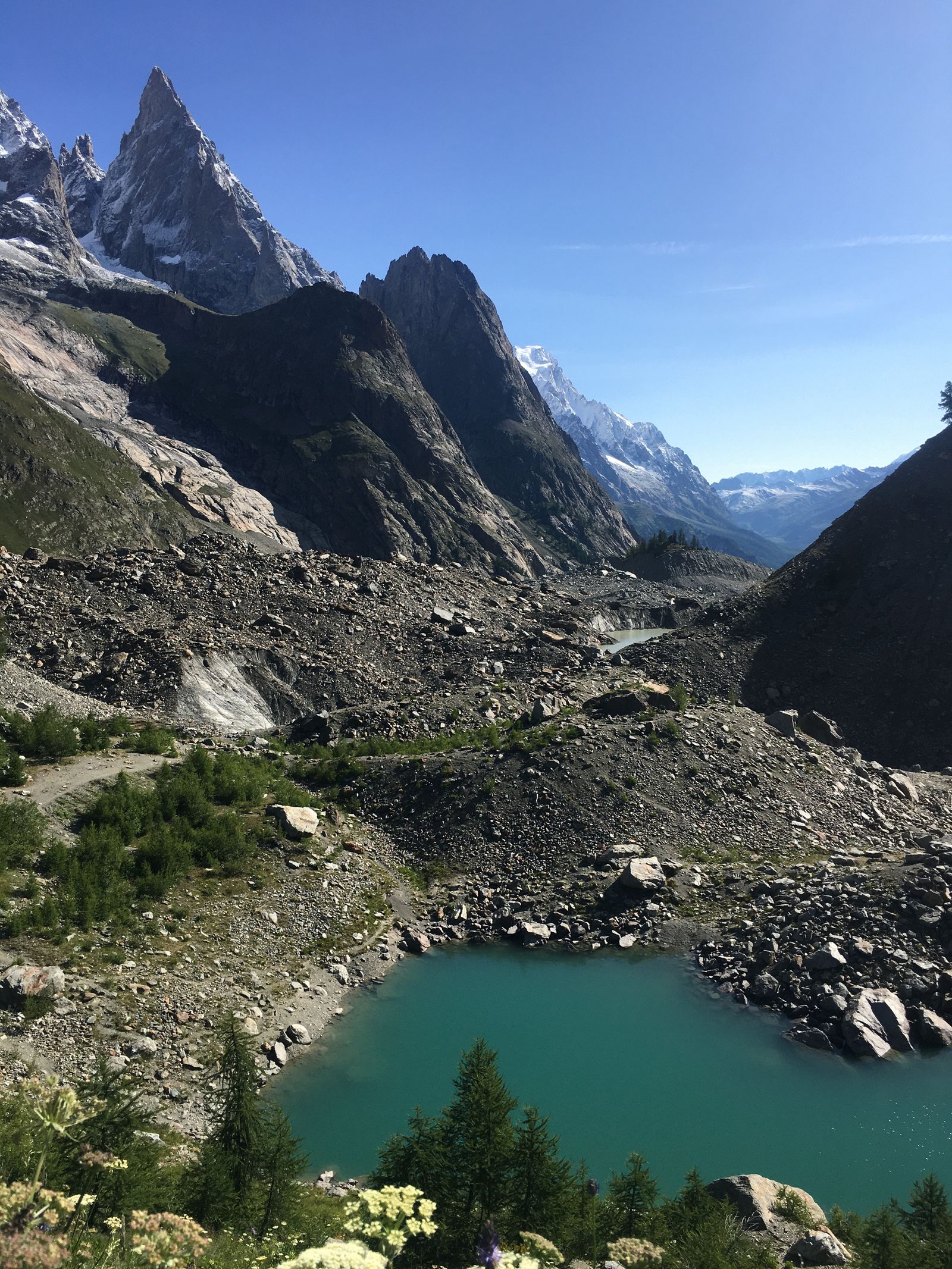 Turquoise glacial lake below snow-covered peaks in Italy's Valle d'Aosta, the Italian flank of the Mont Blanc massif