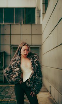 Stylish woman in trendy outfit posing in an urban environment.