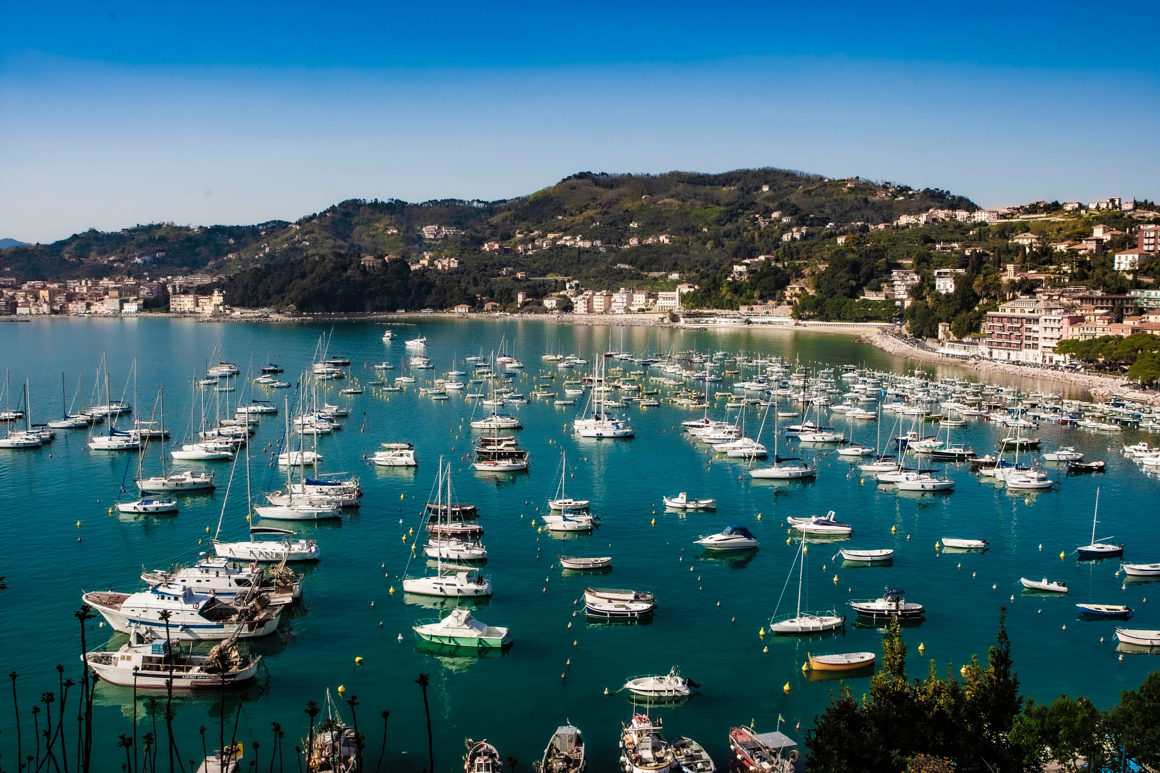 Outstanding Private Day Trip Around Positano and the Amalfi Coast Review 2026 - Picturesque view of boats in an Italian harbor, surrounded by lush hills under a clear sky.