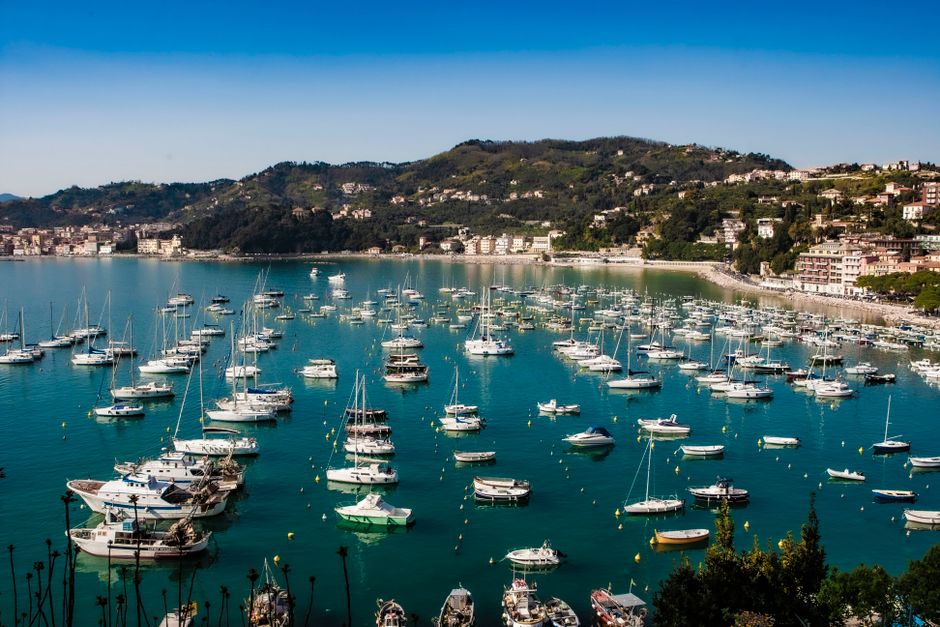 Outstanding Private Day Trip Around Positano and the Amalfi Coast Review 2026 - Picturesque view of boats in an Italian harbor, surrounded by lush hills under a clear sky.
