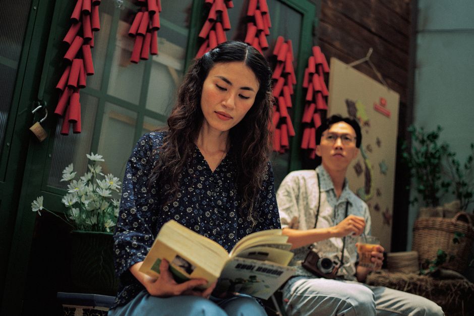Two young adults enjoying a relaxed indoor setting with traditional decorations.