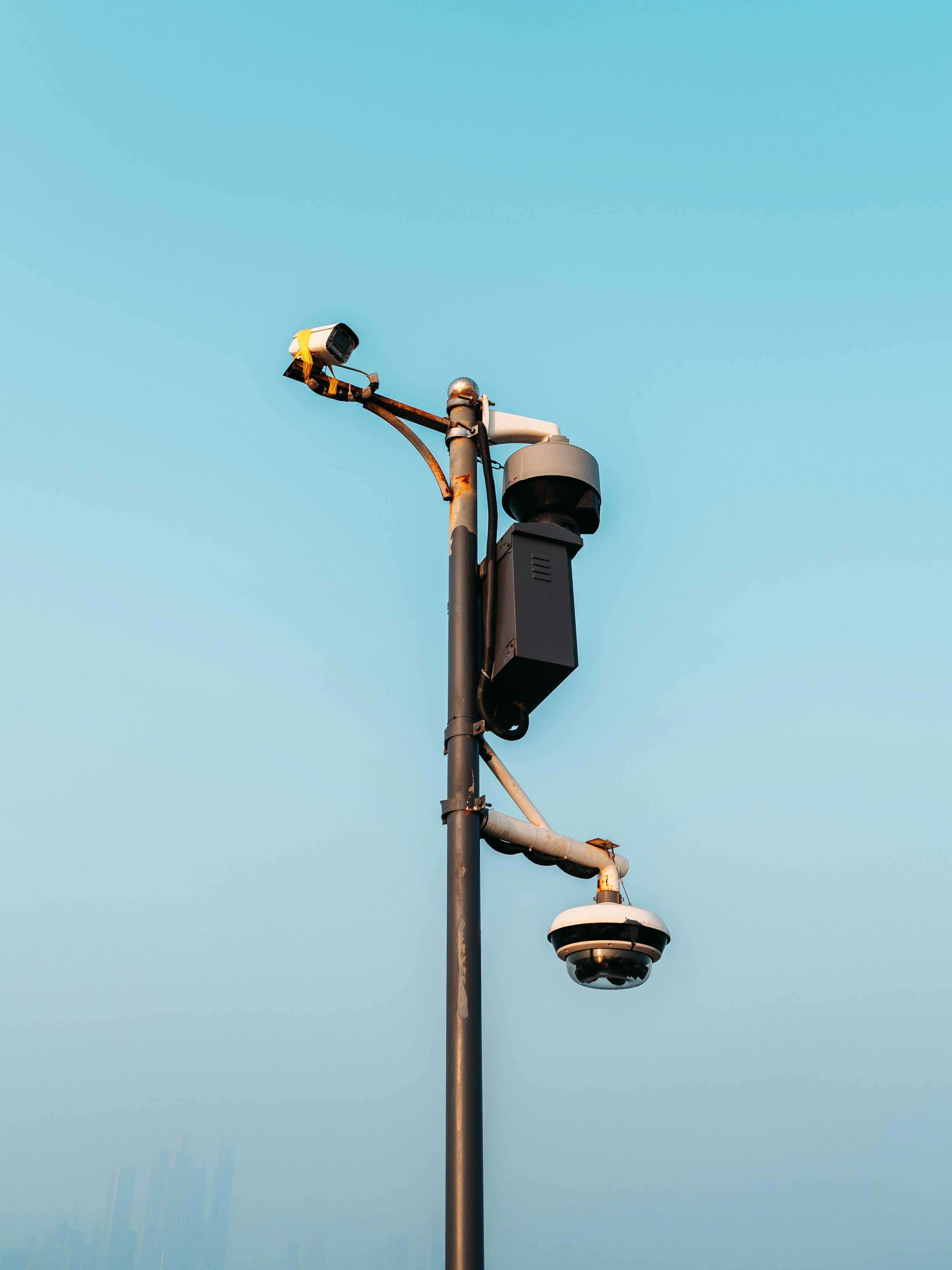 Gratis Cámaras de vigilancia montadas en un poste contra un cielo despejado, simbolizando las medidas de seguridad urbana modernas. Foto de stock