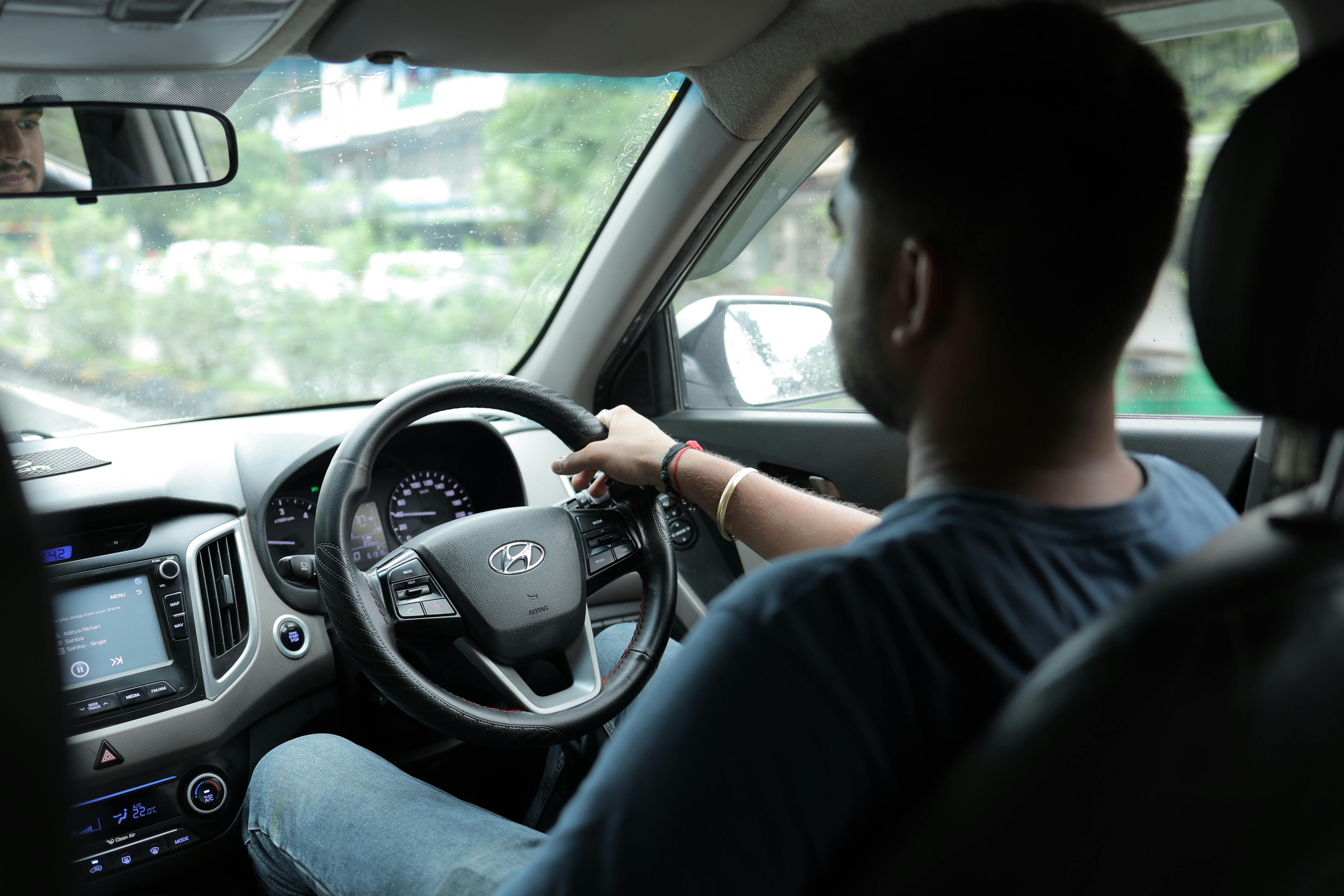 Free View from the passenger seat showing a man driving, focusing on the car's interior and road ahead. Stock Photo