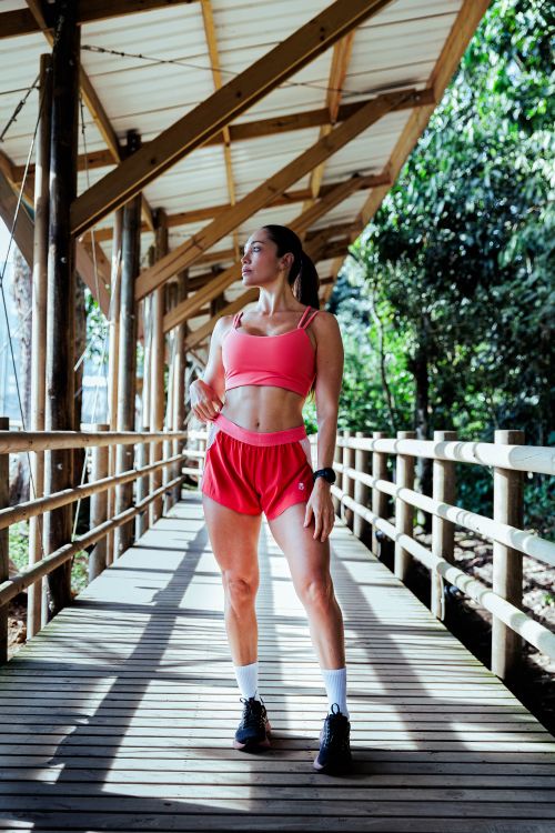 Free Fit woman in athletic wear posing confidently on a wooden walkway outdoors. Stock Photo