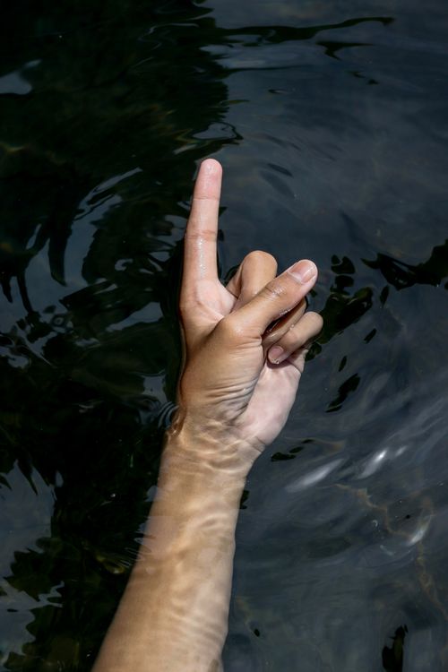 Hand Emerging Hand Emerging from Water with Ripple Effect · Free Stock Photo