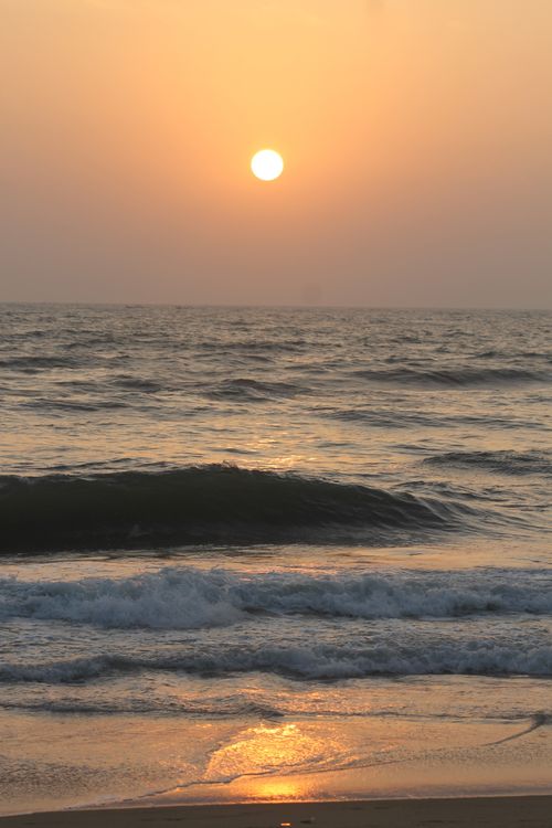 Free Peaceful beach sunset with waves softly crashing onshore, creating a tranquil evening scene. Stock Photo