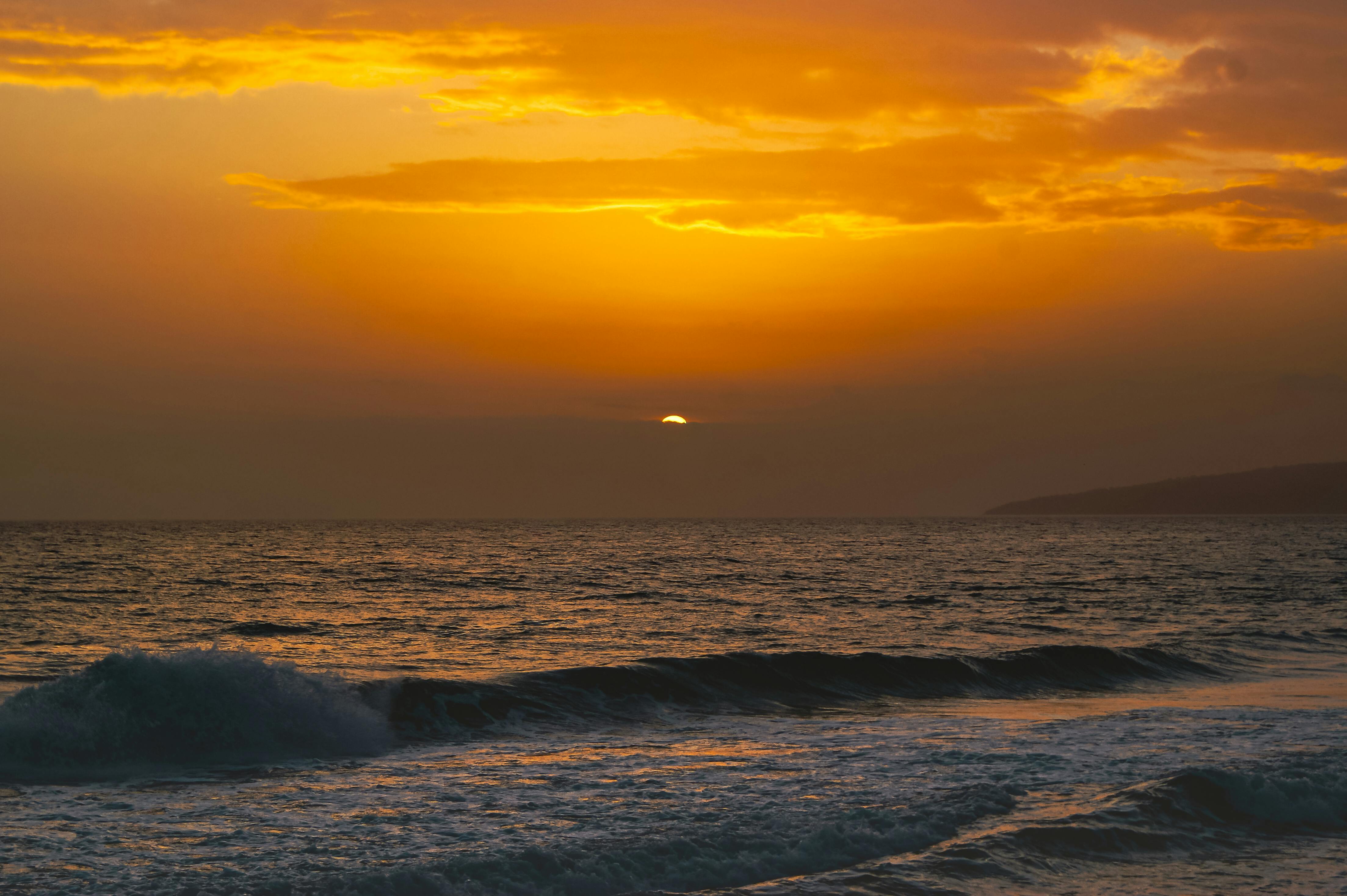 A breathtaking sunset over the ocean with vibrant, warm hues creating a serene atmosphere.