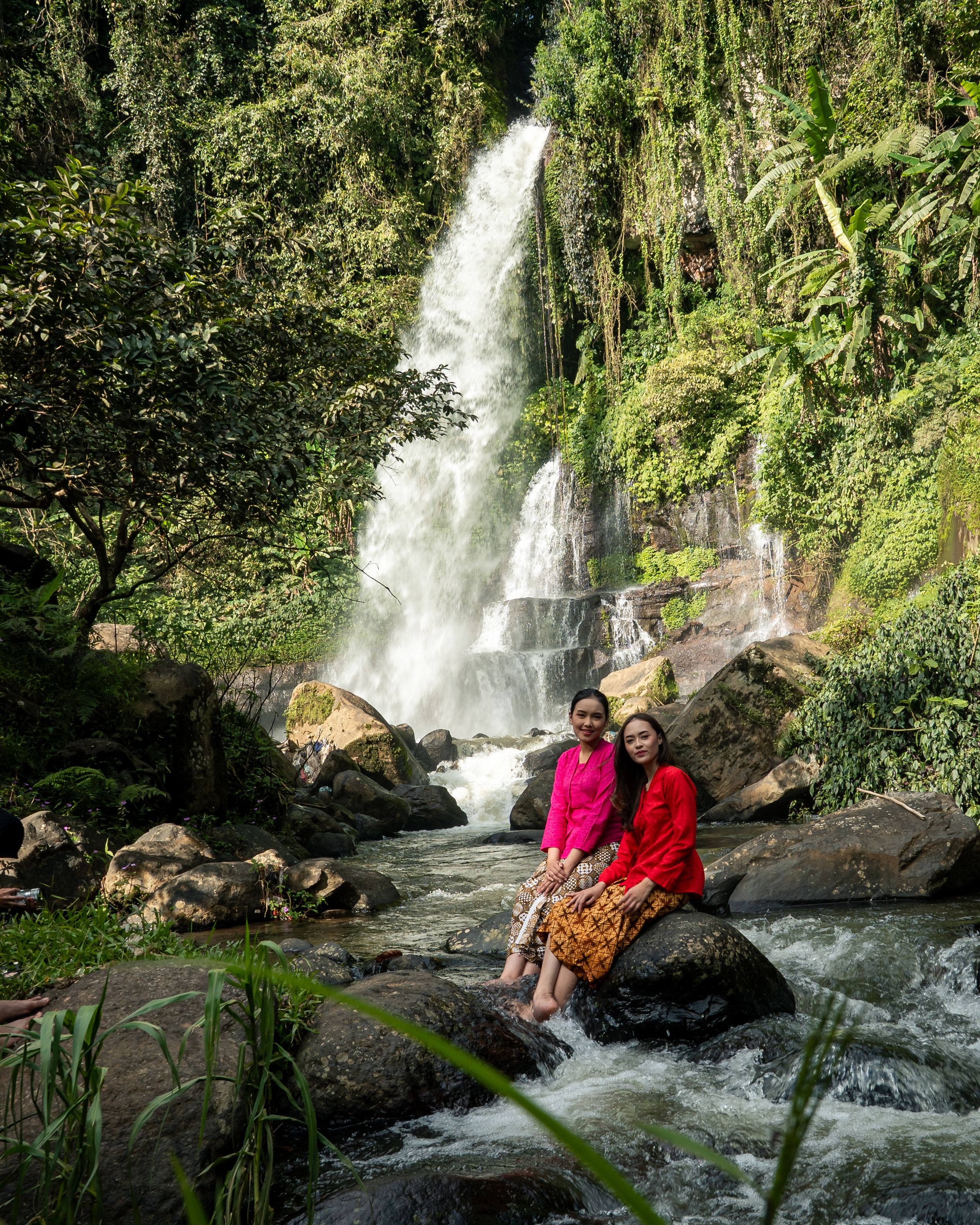 Women Sitting by a Beautiful Waterfall