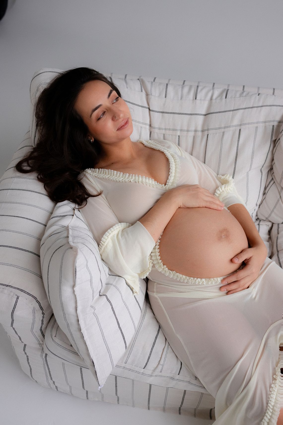 Pregnant woman resting peacefully on a sofa in a calm home setting