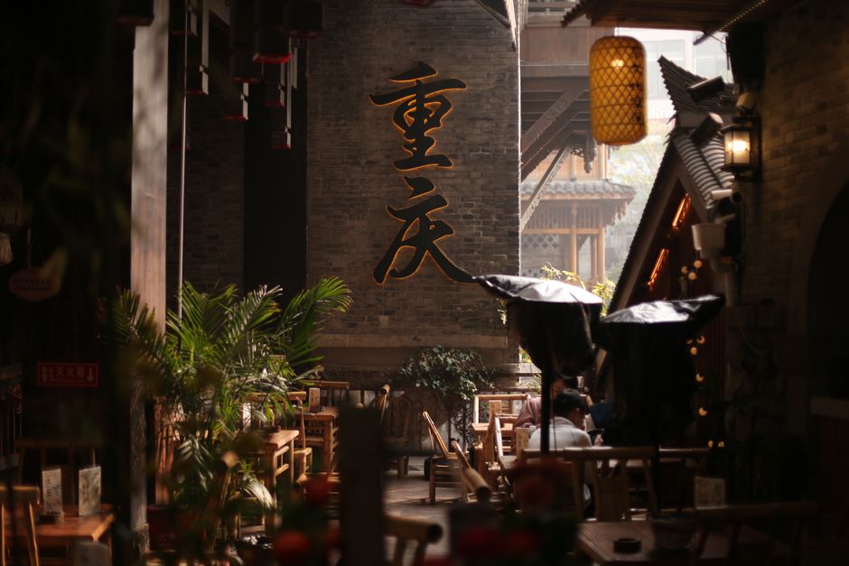 Cozy outdoor cafe in a traditional Chinese alley with warm lighting and cultural decor.