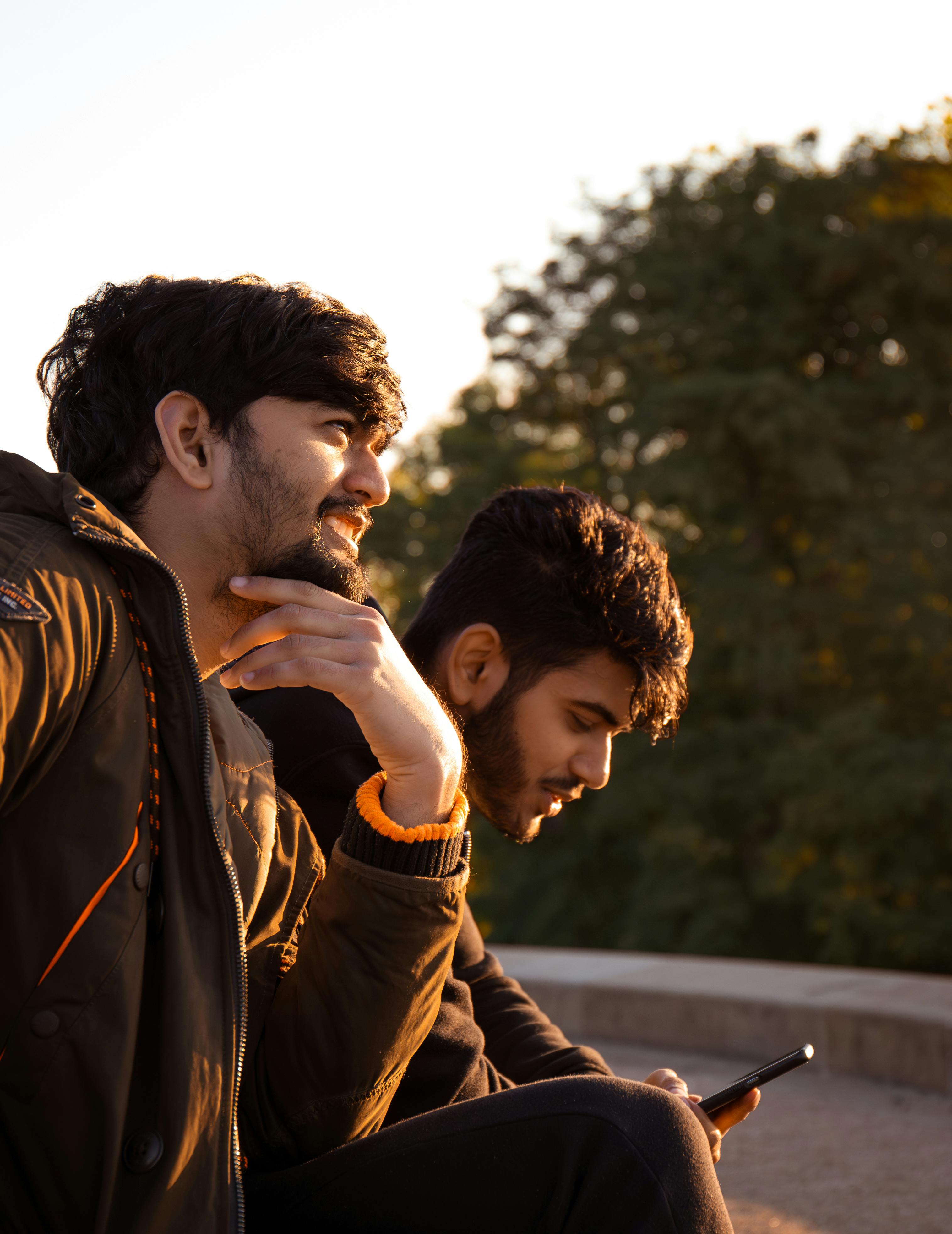 Two young men enjoying the outdoors at sunset, sharing a moment of friendship and relaxation.