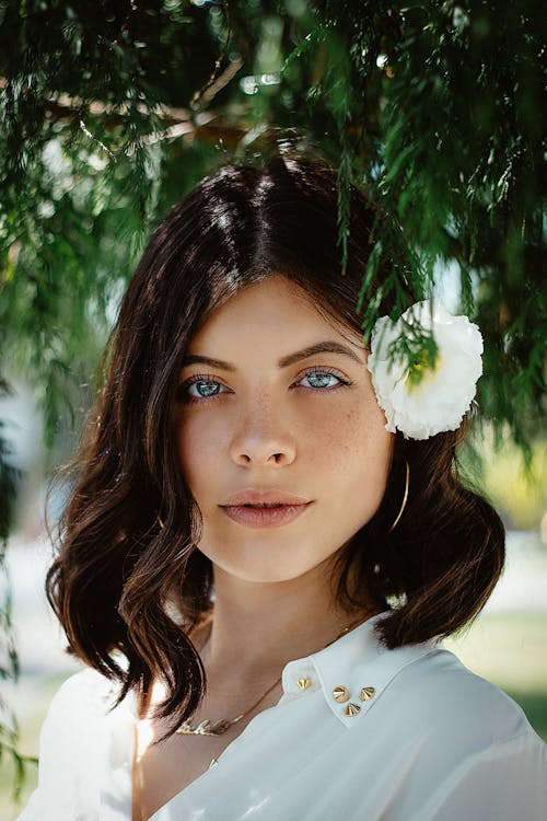 Donna Che Indossa Una Camicia Bianca Con Fiore Bianco Sul Suo Orecchio