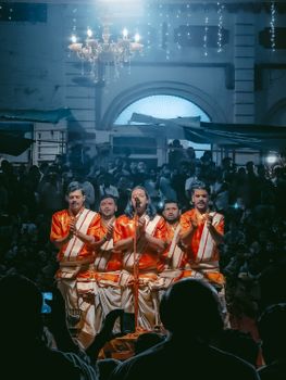 Group of men performing in traditional attire during a cultural event at night.