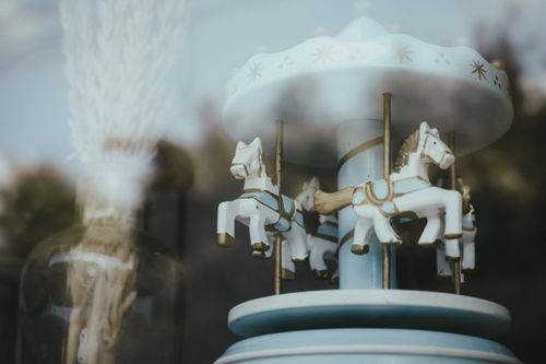 Free Close-up of a vintage carousel with horses reflecting softly in glass. Stock Photo