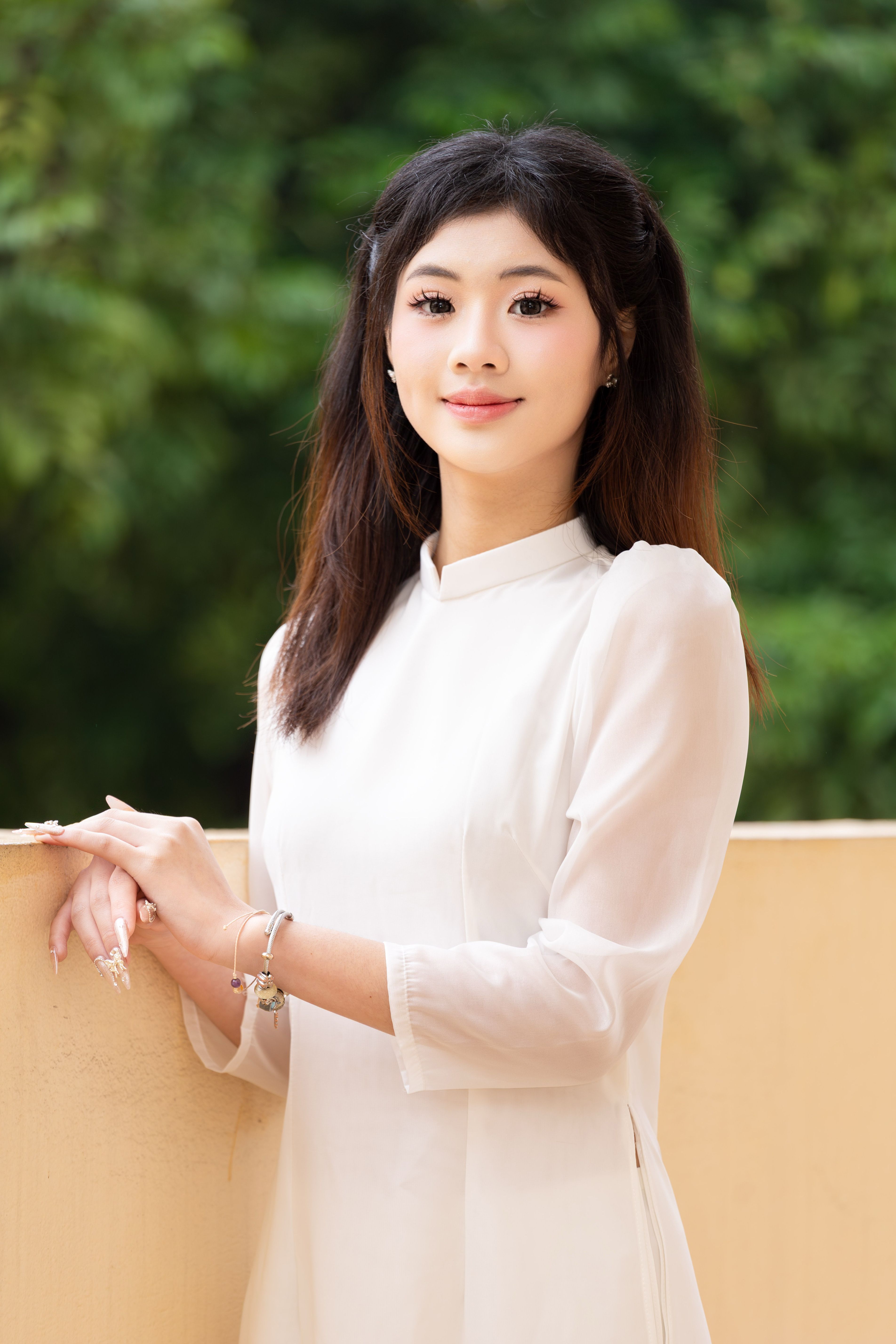 Portrait of a young woman in a white ao dai, Vietnam's traditional dress, captured in Hanoi.