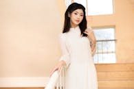 Elegant Young Woman in White Dress on Staircase