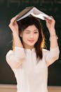 Young Woman Holding Book in Classroom