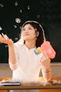Young Woman Playing with Bubbles in Classroom