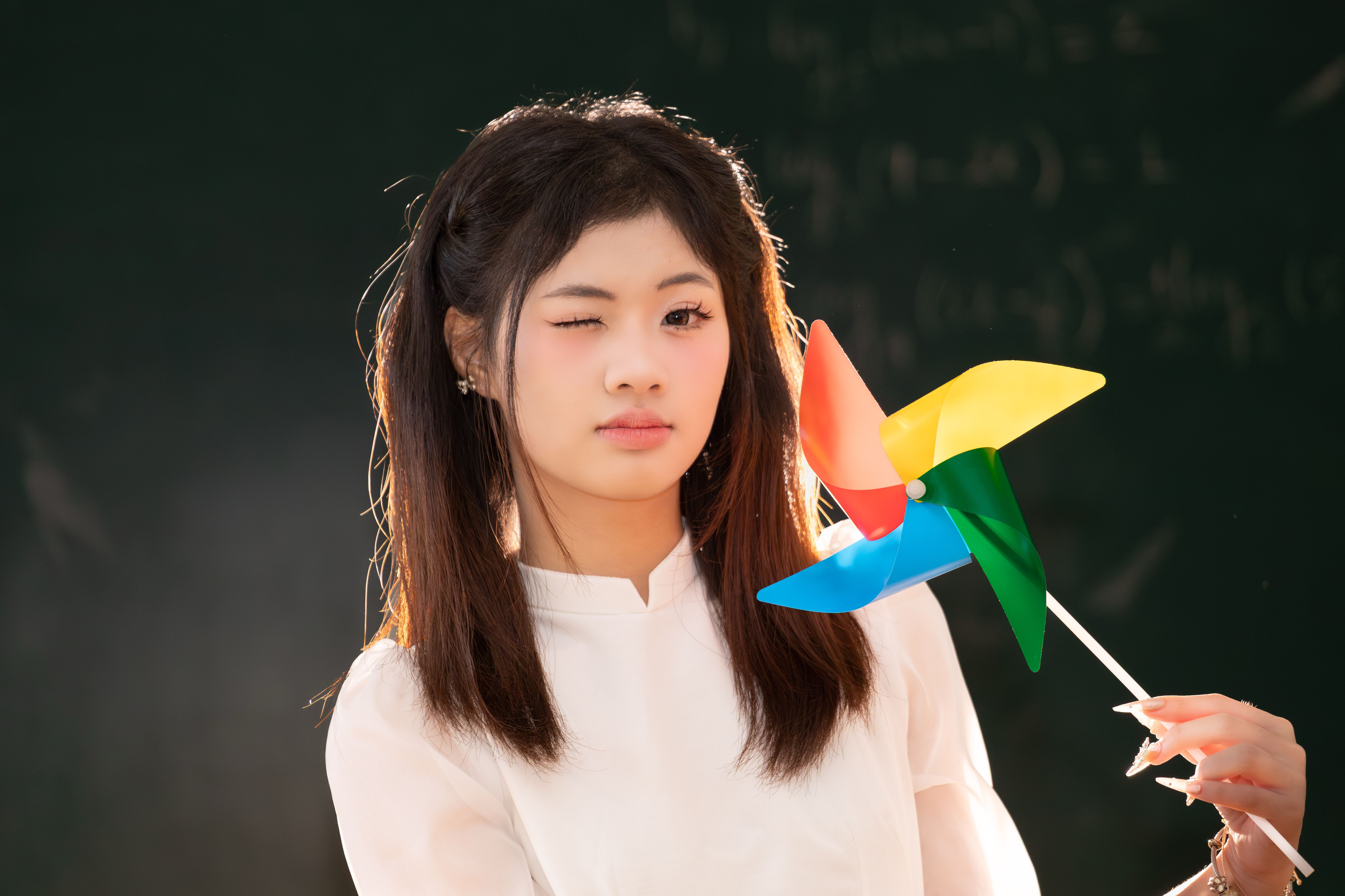 Portrait of a Girl with Colorful Pinwheel · Free Stock Photo