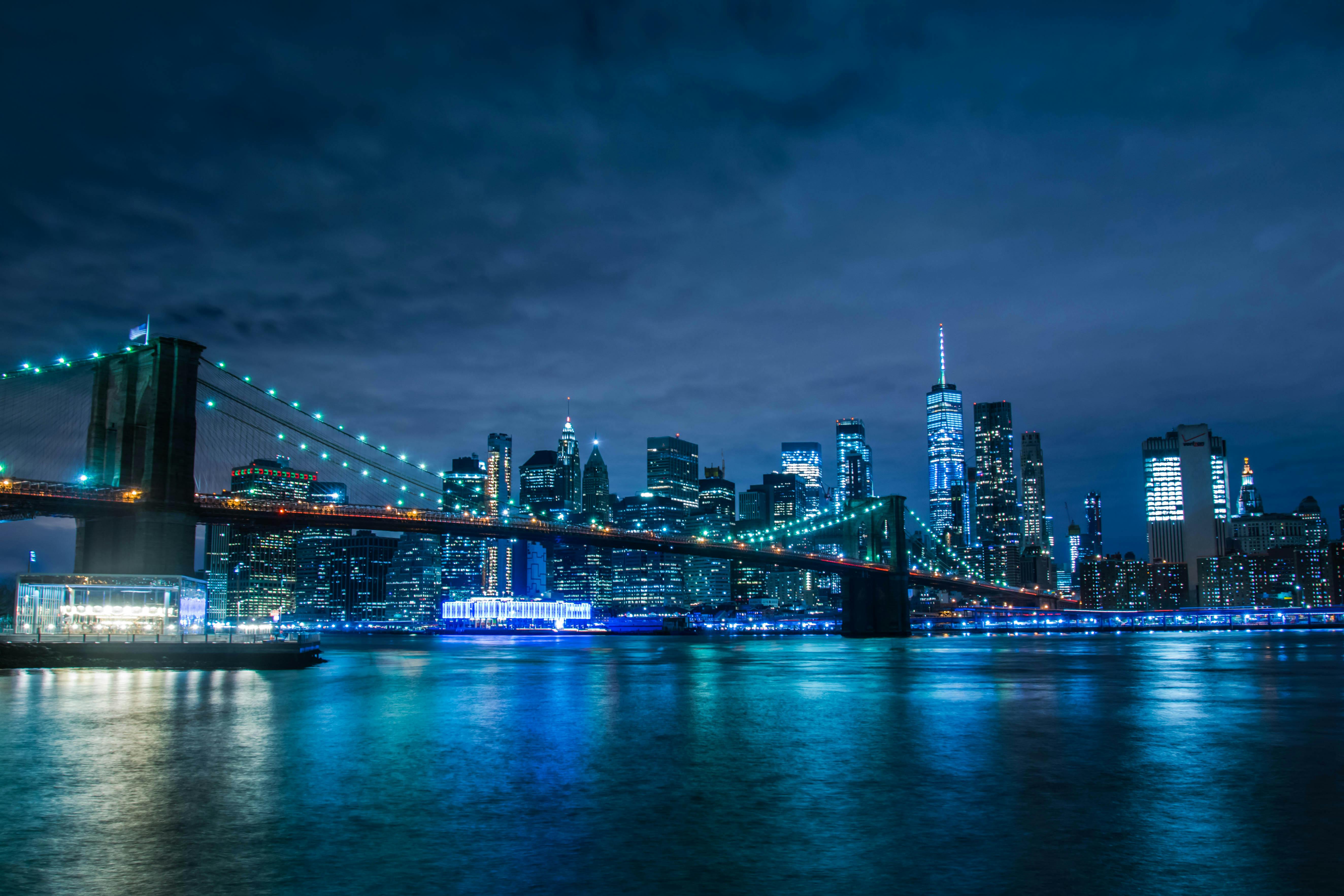 city skyline across body of water during night time