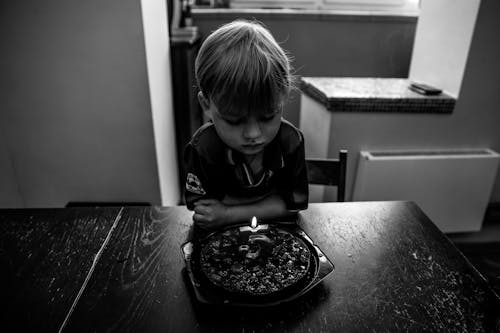 バースデーケーキを見ている少年