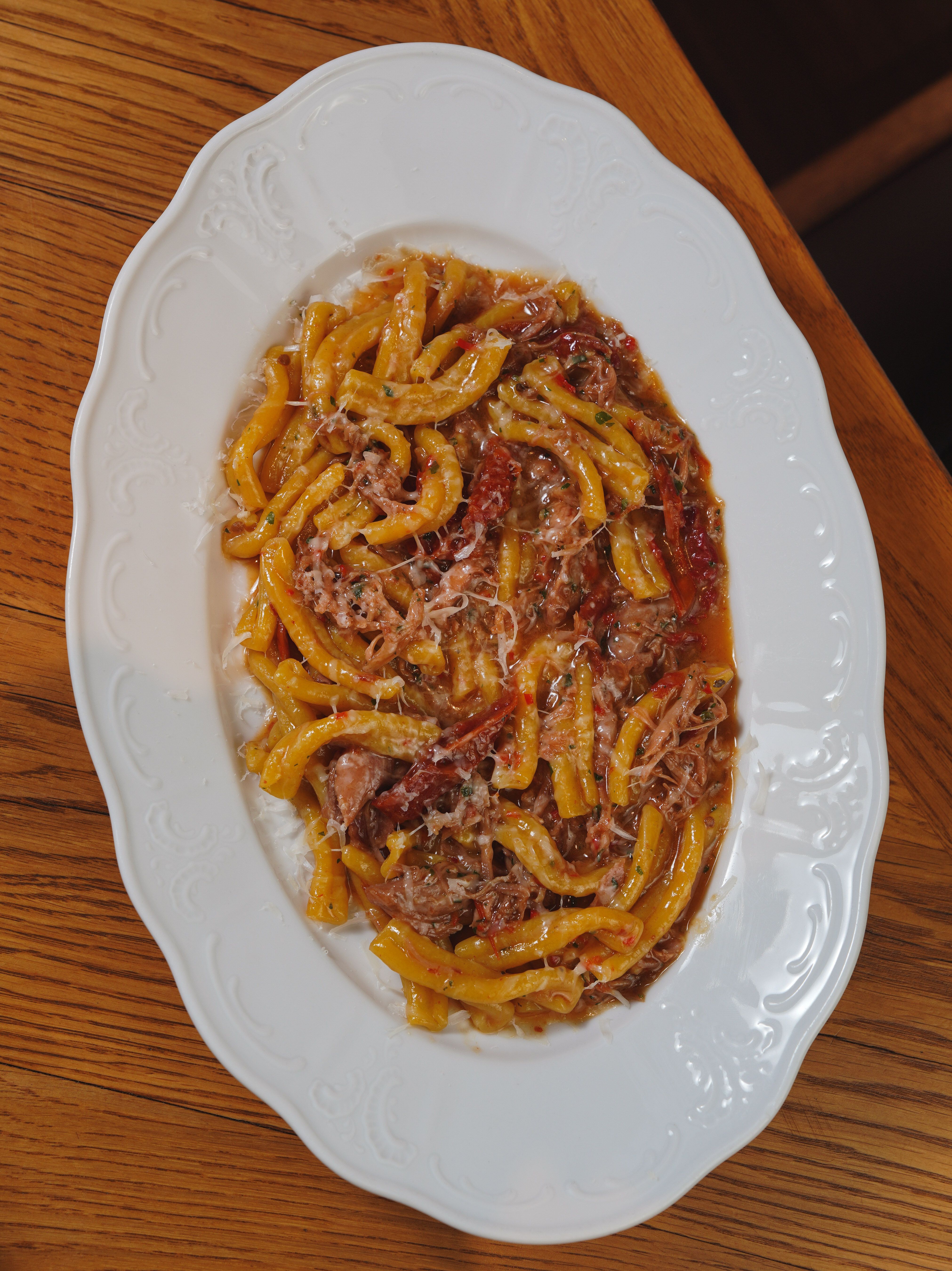 Tasty Italian pasta dish with rich meat sauce served on an elegant white plate.