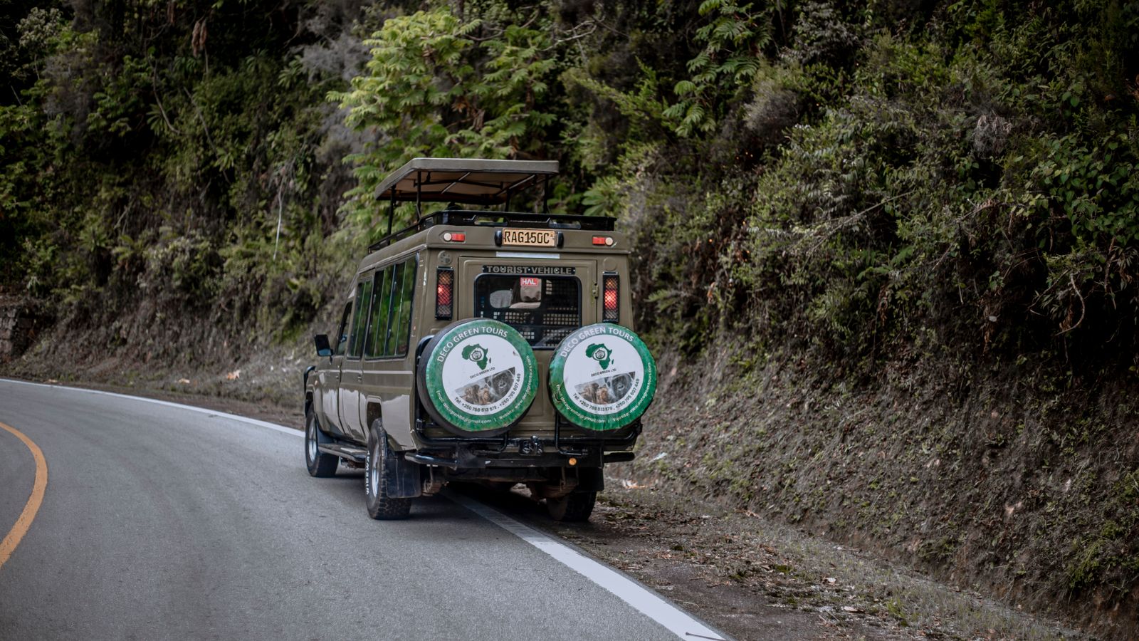 Safari vehicle on winding forest road, DR Congo