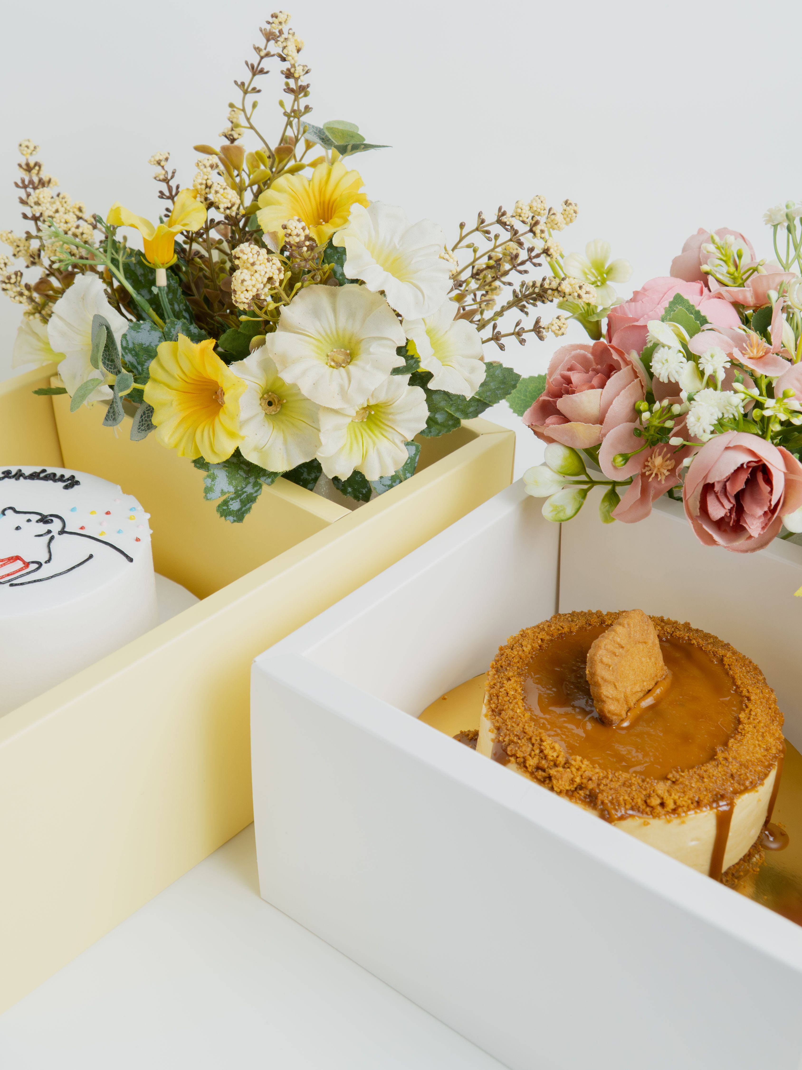 Elegant floral arrangements alongside caramel and birthday cakes.