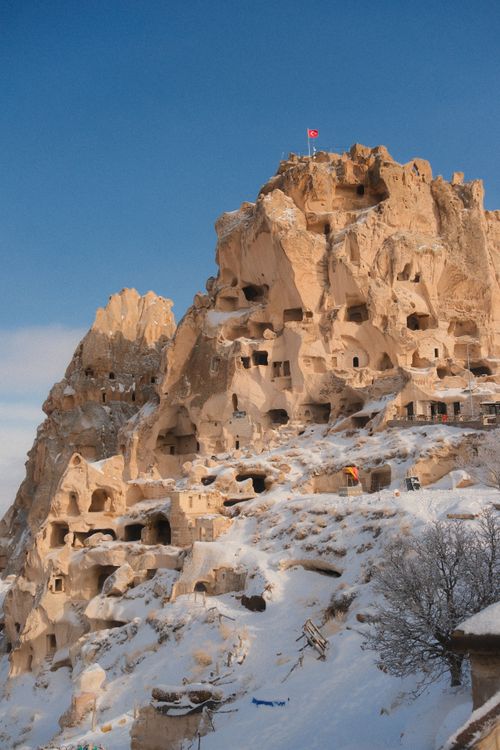 Free Scenic view of snow-covered rock formations and ancient cave dwellings in Cappadocia, Turkey. Stock Photo