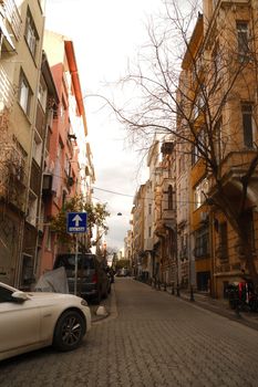 Explore a quaint city street lined with colorful historic buildings and parked cars.