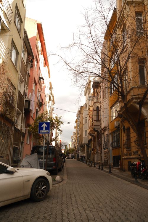 Free Explore a quaint city street lined with colorful historic buildings and parked cars. Stock Photo