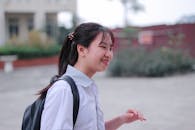 Cheerful Student Walking Outdoors in Schoolyard