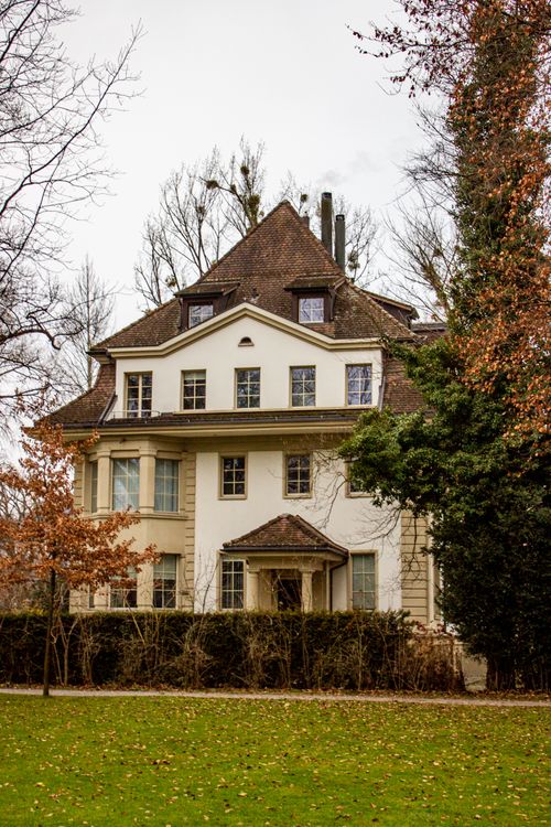 Free Elegant historic house in Lucerne, surrounded by lush greenery and autumn colors. Stock Photo