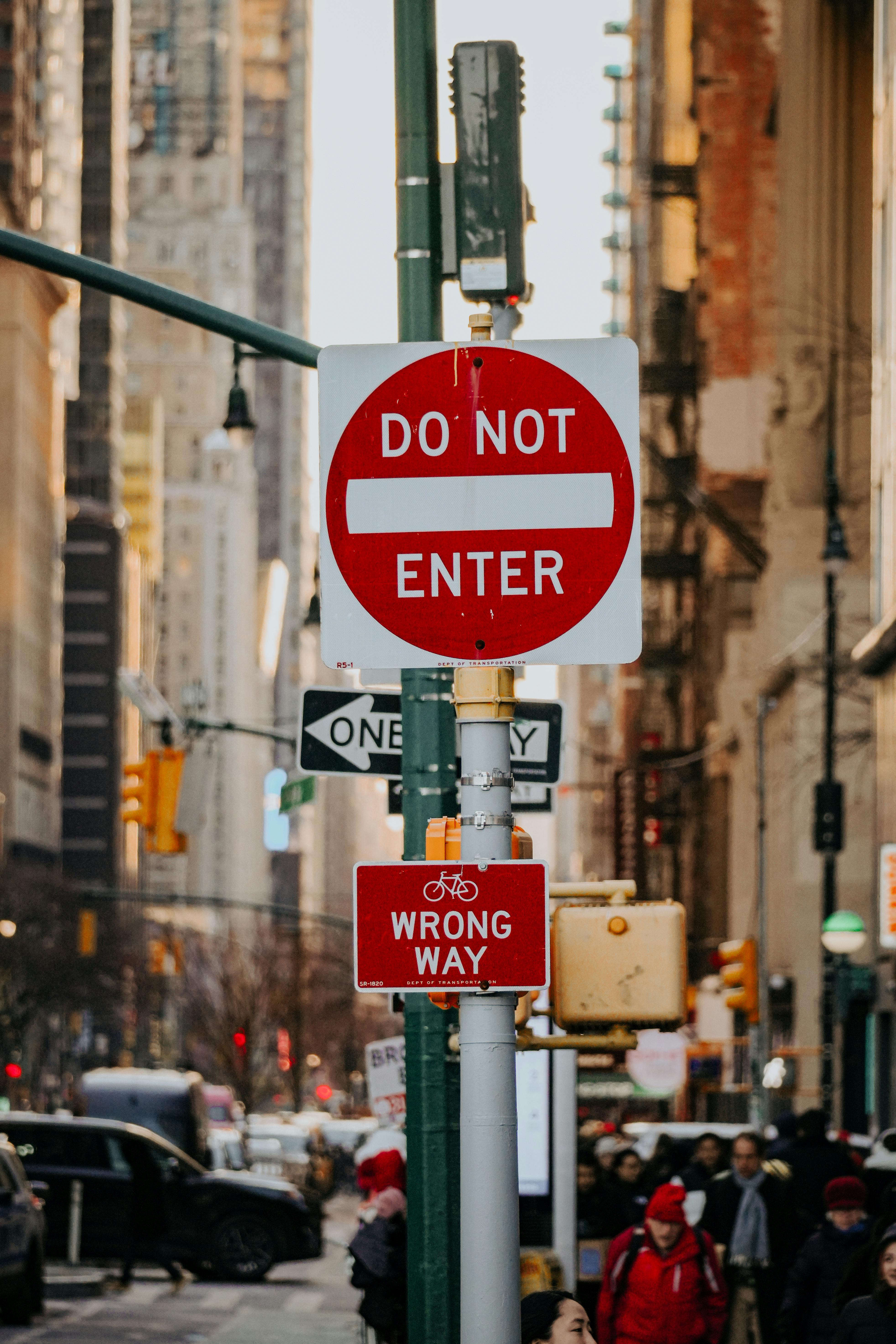 "Do Not Enter" sign on a busy New York City street with urban backdrop.