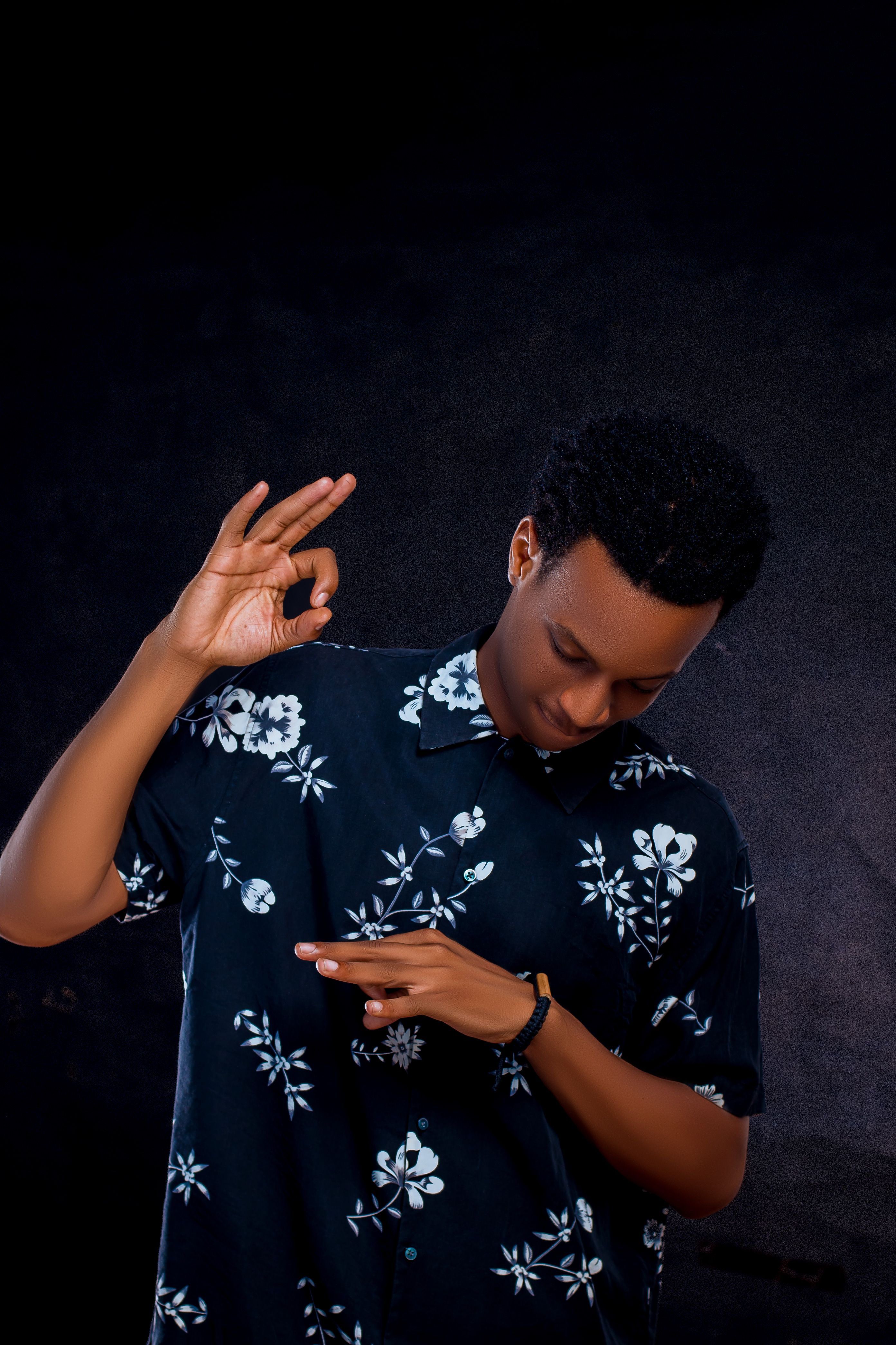 Stylish man making hand gestures in dark setting · Free Stock Photo