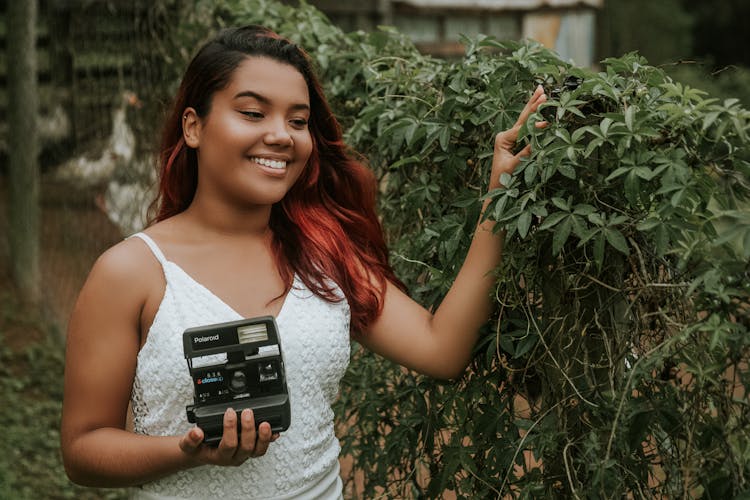 Photo Of Woman Holding Polaroid Camera